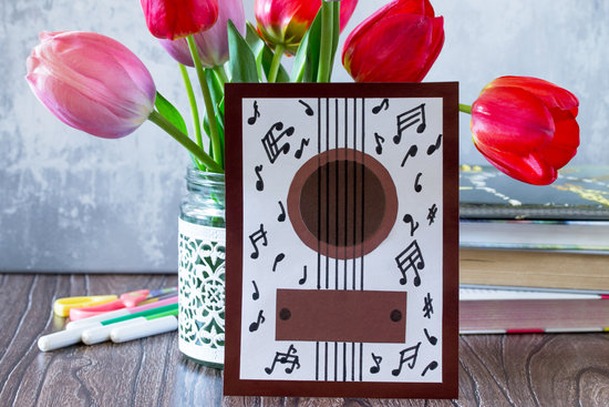 Birthday postcard guitar on desk. Congratulatory musical card. Children's art project, craft for children. Craft for children.